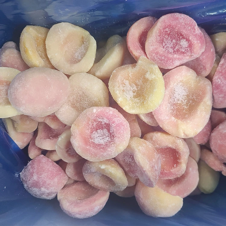 Individually frozen peach halves showing color and surface ice Frosted yellow and white frozen peach halves inside a bulk liner