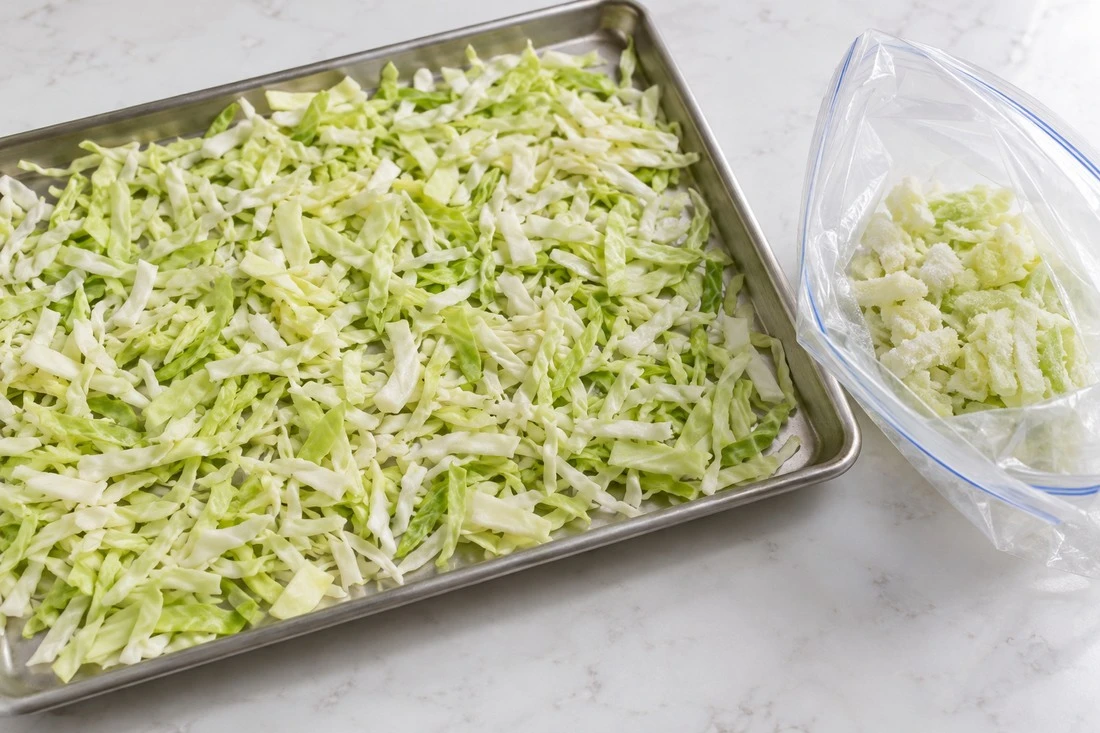 Cabbage shreds on a tray beside a freezer bag Cabbage shreds on a tray beside a freezer bag