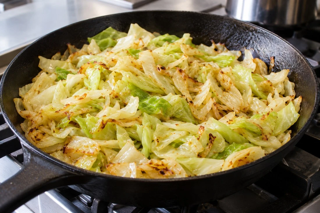 Fried cabbage with golden edges in a black skillet Fried cabbage with golden edges in a black skillet