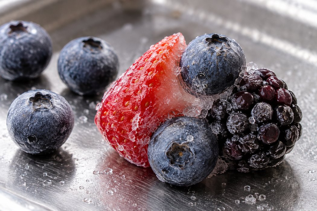 Ice at berry contact points Trimmed strawberry piece, blueberries and blackberry joined by ice at their contact surfaces