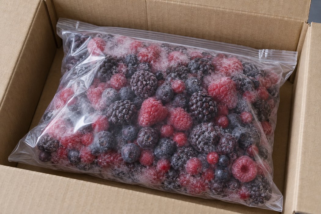 Pack condition before opening Sealed transparent bag of frozen mixed berries inside a cardboard carton