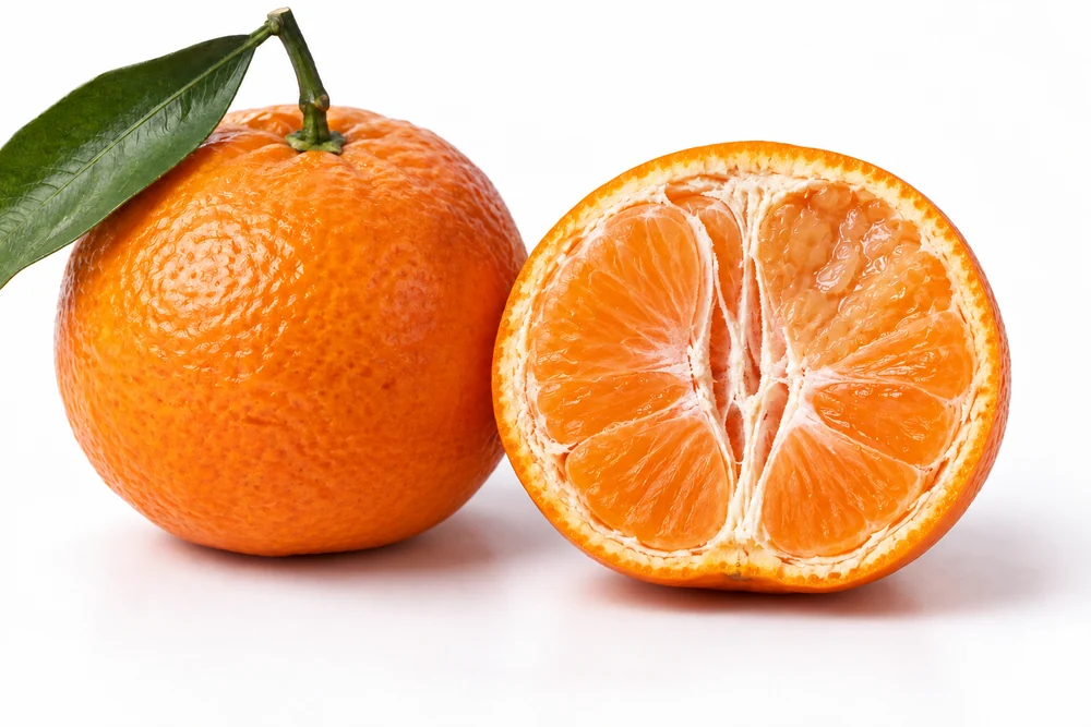 Intact mandarin next to cutaway with localized damaged pulp