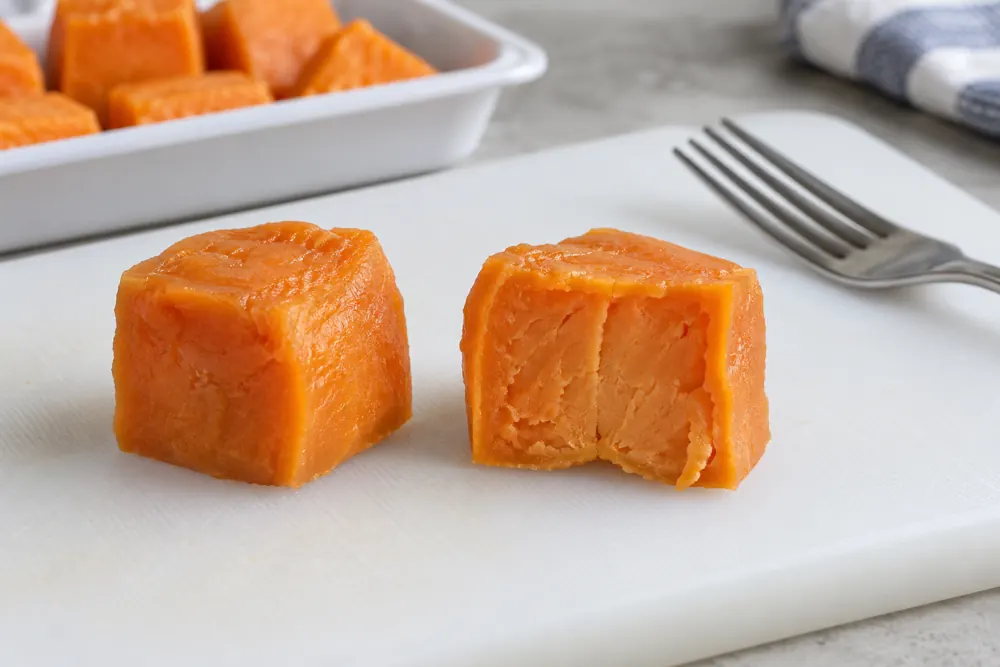 Heated sweet potato cube cut open to inspect the center