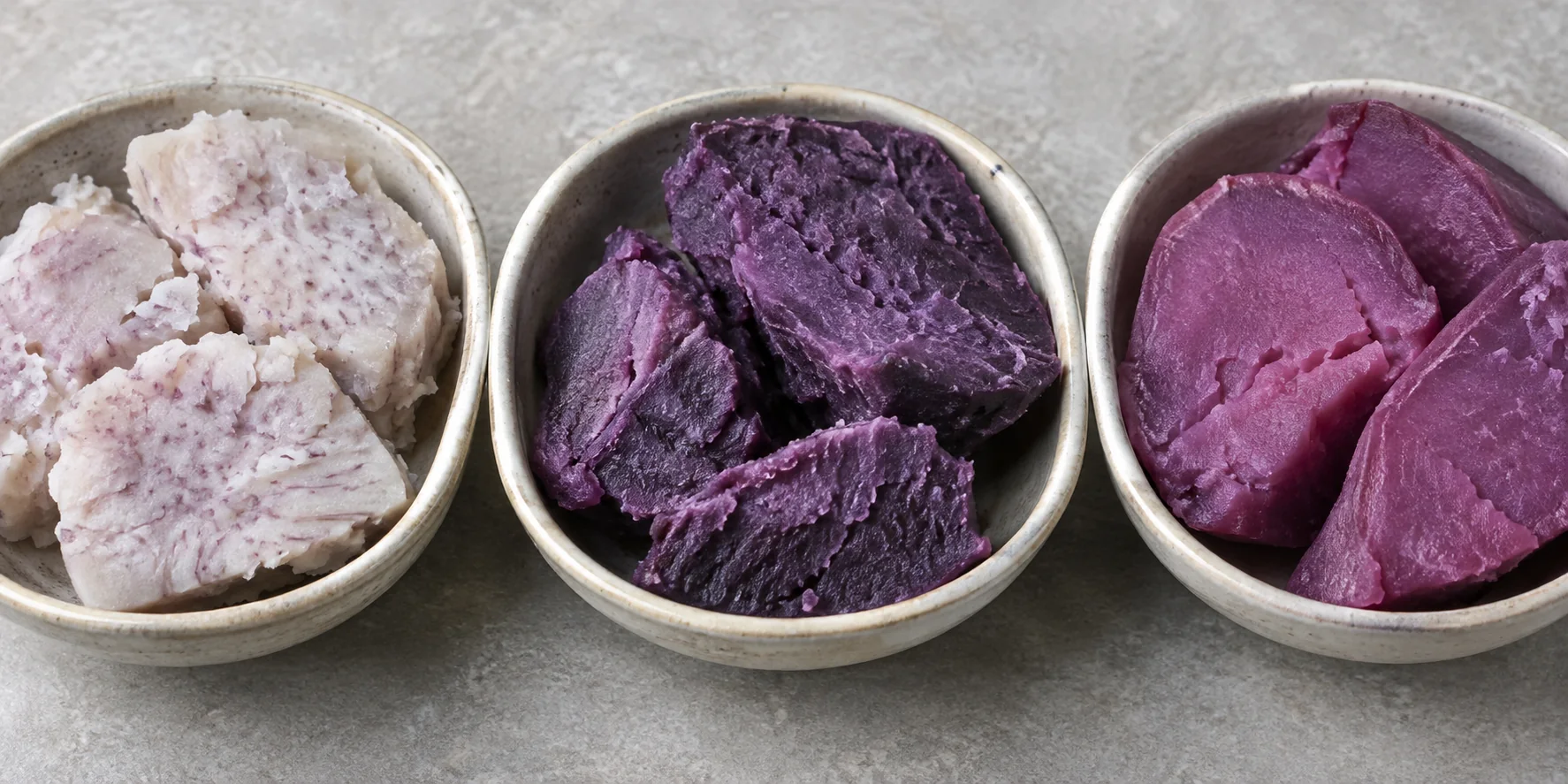 Cooked taro, ube and purple sweet potato cut surfaces side by side.