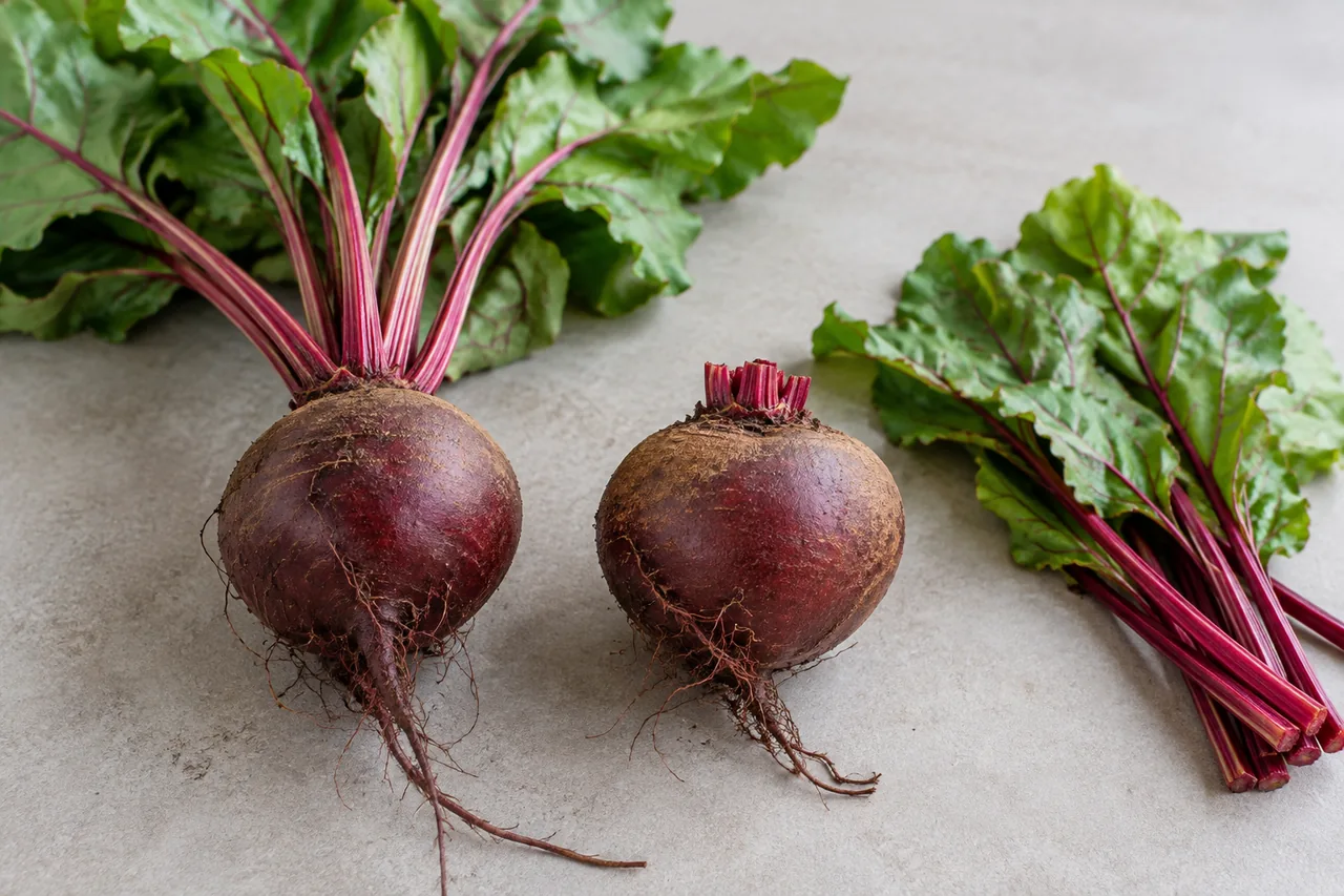 A beet with leaves beside a topped root with intact skin and crown.
